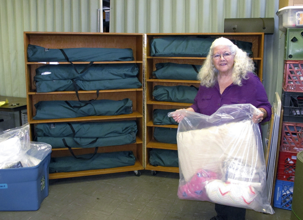 Judi Joy, shelter manager at the Good Samaritan Haven in Barre, Vt., with a set of linens that will be sent to an emergency shelter for the state's homeless population. The center expanded its operations this fall with 14 overflow beds at a church.
