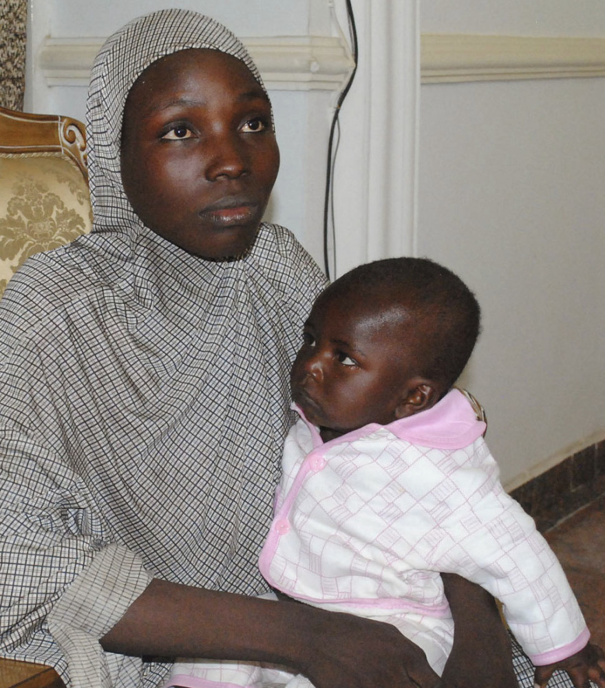 A rescued Chibok girl holds the 10-month-old boy whom she had with a Boko Haram fighter.
