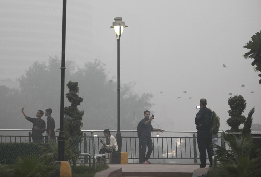 Indians take selfies at a public park enveloped by thick smog in New Delhi on Saturday. 