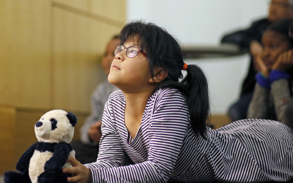 Ten-year-old Eleanor Lo (with Panda the panda) listens to illustrator Ashley Bryan during an appearance at Portland Public Library to promote his book, "Freedom Over Me." 