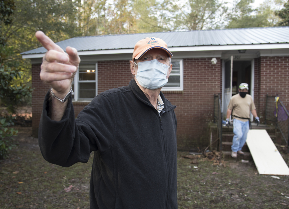 Bill Jones, 77, stands outside his home that was heavily damaged by floodwater. Nearly a month since a flood  consumed the town, few have returned.