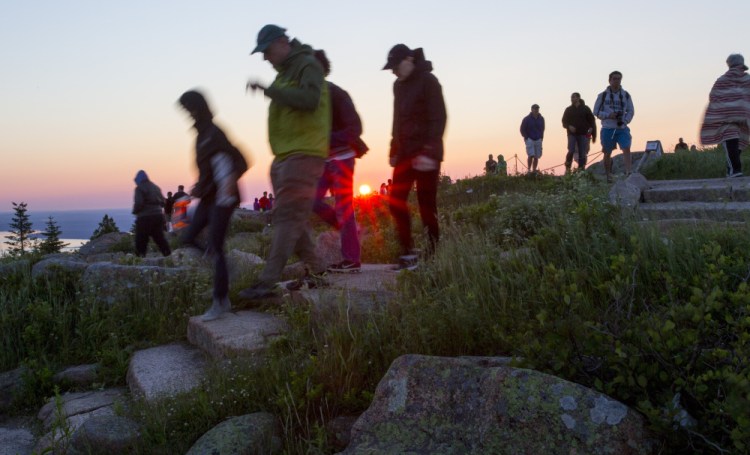 Visitors leave Cadillac Mountain after a glimpse of a sunrise in June. Officials at Acadia National Park are in the early stages of developing a strategy to confront traffic jams, crowds and parking shortages at the popular tourist attraction.