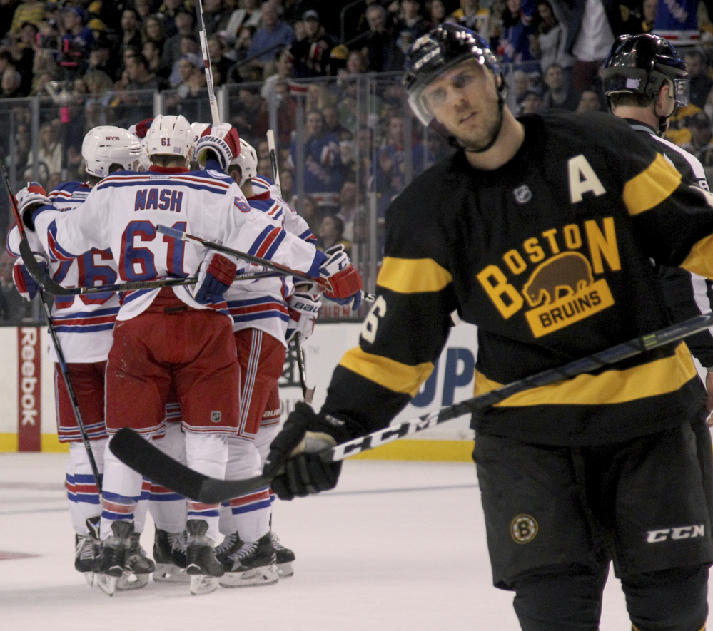 Rangers players surround Nick Holden after his first-period goal Saturday as Bruins center David Krejci reacts. New York won, 5-2.