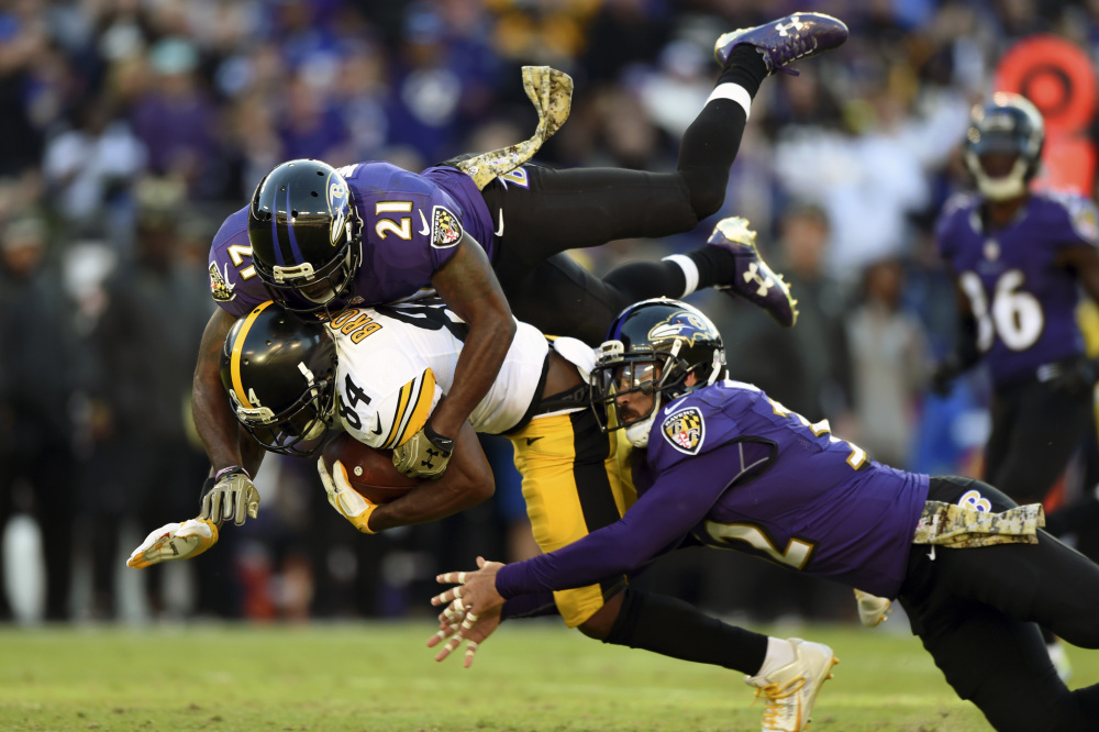 Steelers receiver Antonio Brown is brought down by Ravens safeties Lardarius Webb, top, and Eric Weddle during Sunday's game in Baltimore. Despite losses in their previous four games, the Ravens moved into a tie with Pittsburgh atop the AFC North standings with a 21-14 victory.