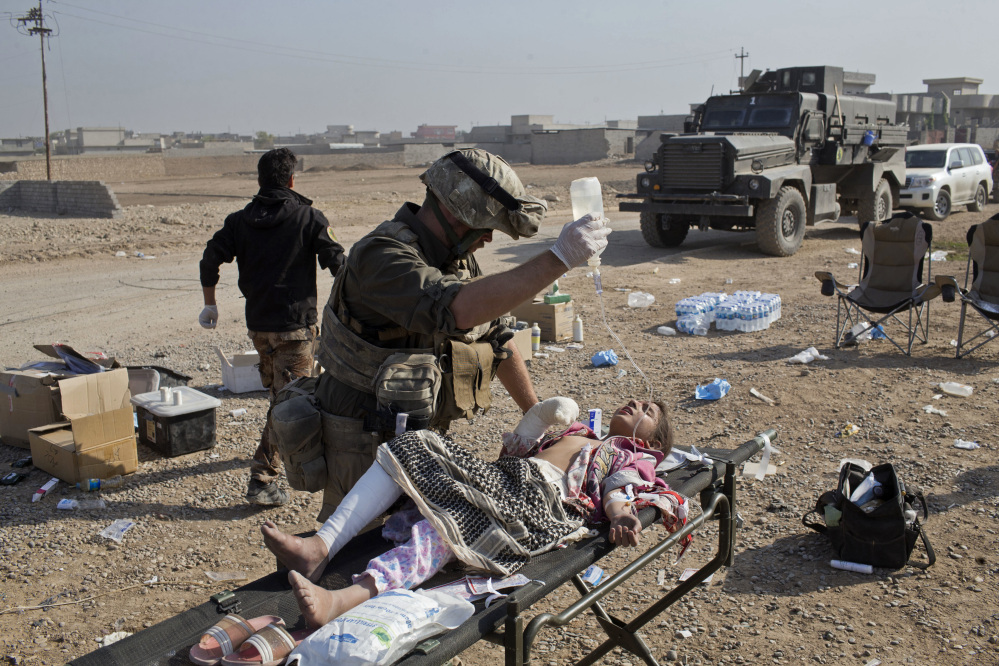 Derek Coleman, a volunteer medic, treats a wounded Iraqi special forces soldier at a field clinic in Gogjali, on the eastern outskirts of Mosul, Iraq, on Sunday.