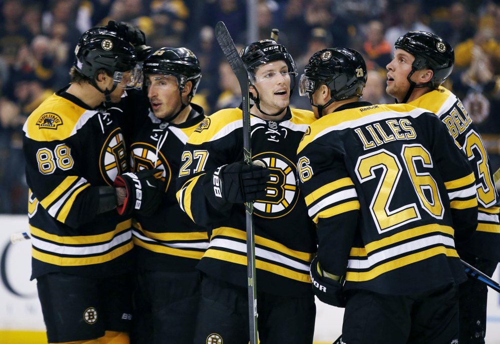 From left, Bruins David Pastrnak, Brad Marchand, Austin Czarnik, John-Michael Liles and Matt Beleskey celebrate Marchand's goal in the second period Monday night in Boston. The Bruins went on to a 4-0 win.