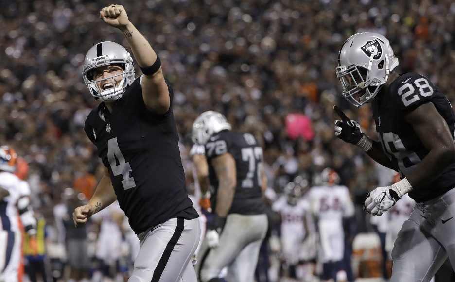 Oakland quarterback Derek Carr, left, celebrates a touchdown run by Latavius Murray, right, during the Raiders' 30-20 win over the Broncos on Sunday.