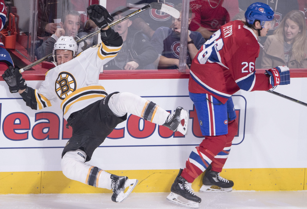 Boston's Ryan Spooner is checked into the boards by Montreal's Jeff Petry in the first period Tuesday night in Montreal. The Canadiens scored a late goal for a 3-2 win.