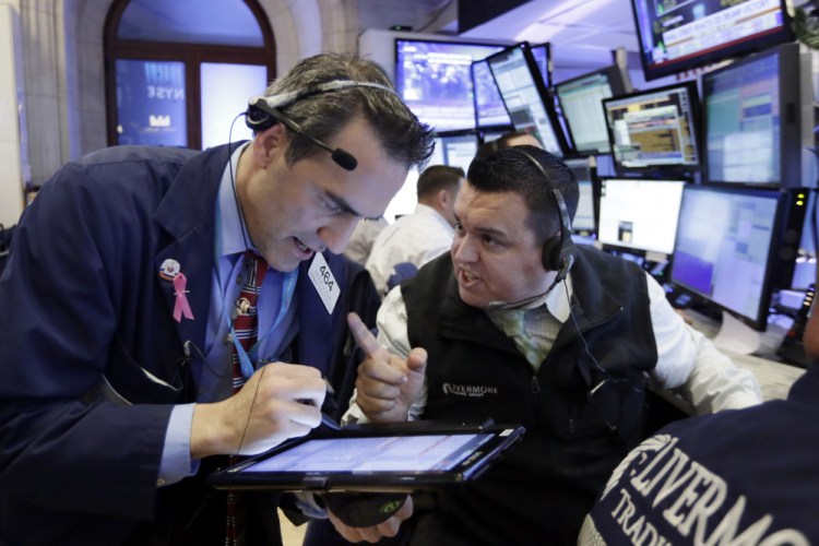 Traders Gregory Rowe, left, and Robert Finnerty work on the floor of the New York Stock Exchange on Wednesday. Stocks started to move higher in midday trading after futures plunged Tuesday night on the prospect of a Trump victory.