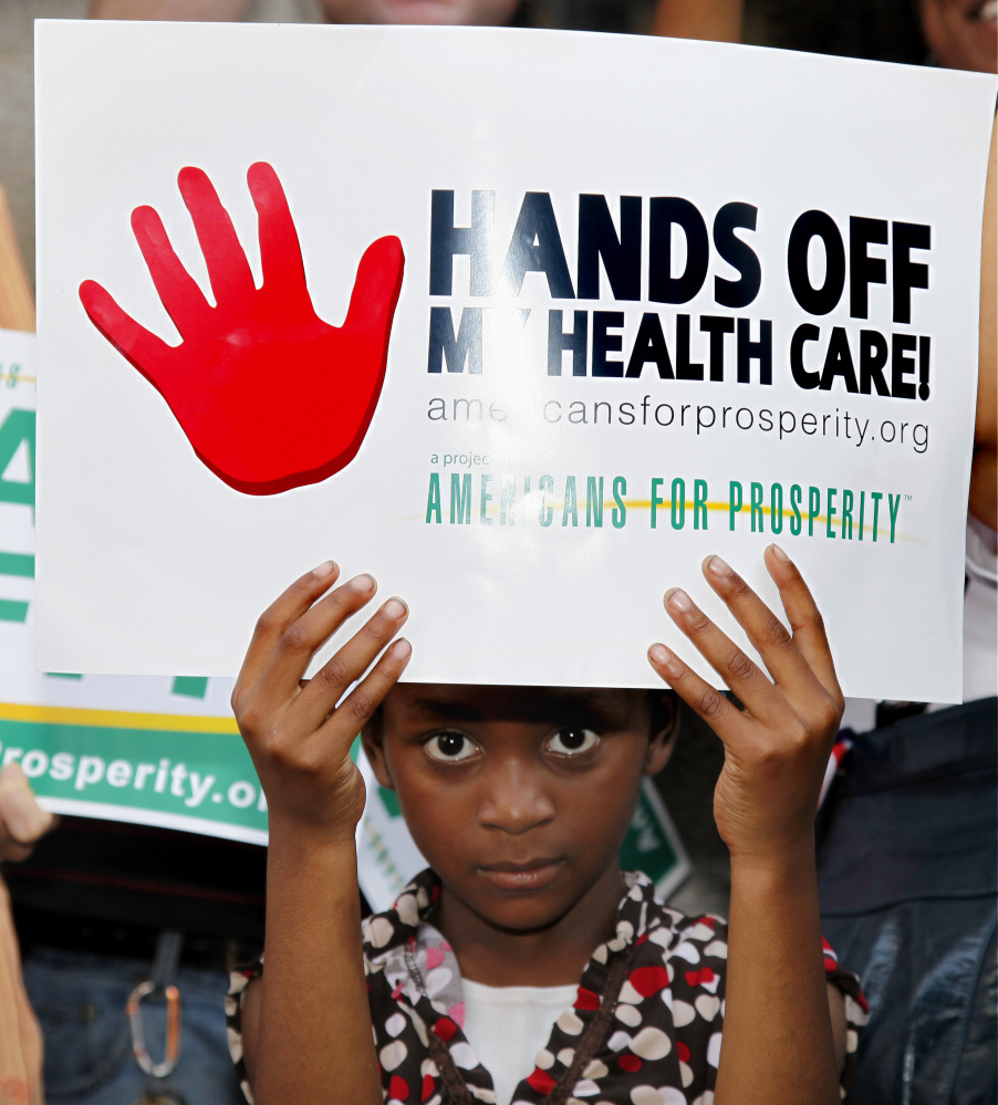 Najhe Crenshaw, 7 of Atlanta, holds a sign during a protest against President Obama's health care reform plan outside the  11th Circuit Court of Appeals in Atlanta in 2011.  A three-judge panel of the 11th Circuit Court of Appeals was hearing arguments on whether to reverse a Florida judge's ruling that struck down the law.
