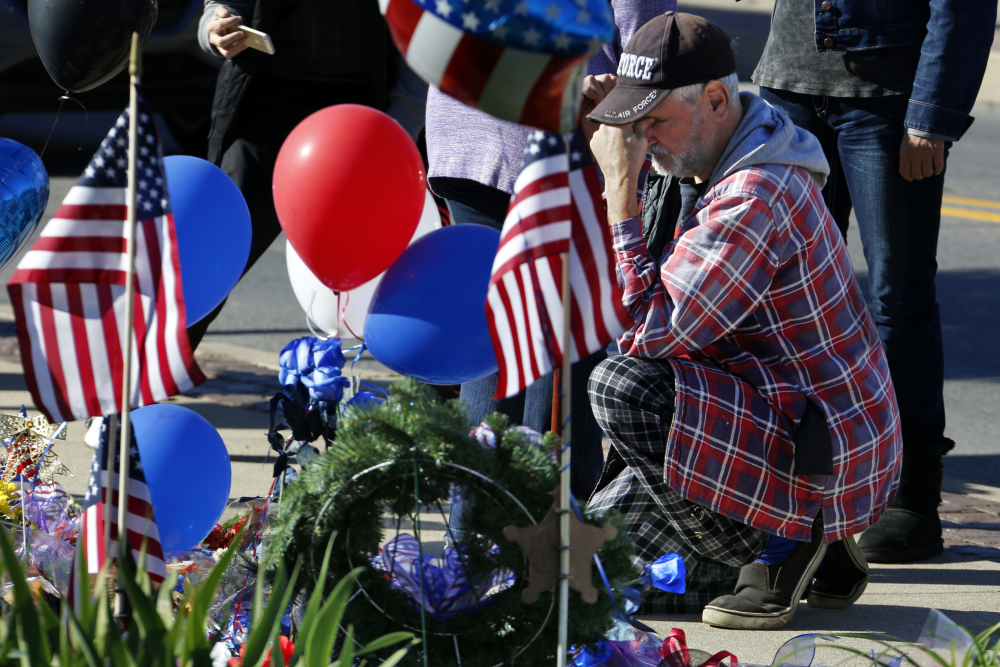 John Kelemen of Canonsburg, Pa., prays at a makeshift memorial after two Canonsburg, Pa., police officers were shot, one fatally, early Thursday in Canonsburg, Pa., by a man with a history of domestic abuse.