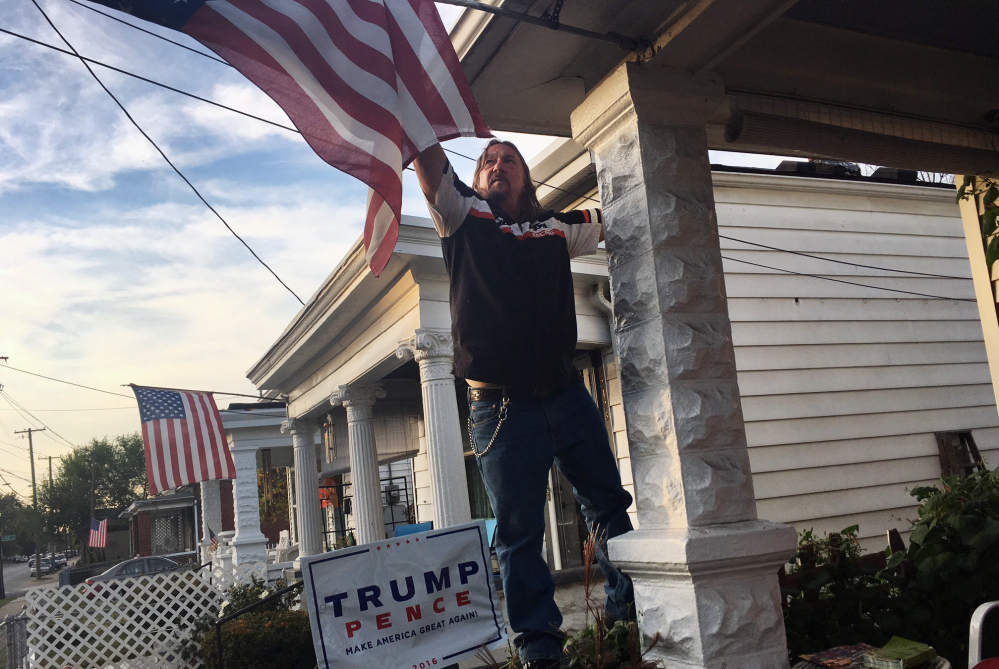 Terry Wright, 59, a retired union painter, adjusts the U.S. flag on the porch of his Louisville, Ky., home on Tuesday. Wright, a registered Democrat backing Republican presidential candidate Donald Trump, says he has given up on his old party.