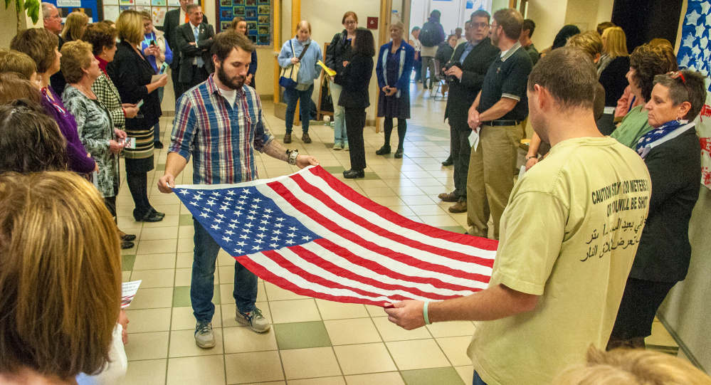 Nursing students Chad Ceccarini, left, an Air Force veteran, and Nicholas Whitmore, an Army veteran, fold a flag during a Veterans Day ceremony Thursday in the Randall Student Center at the University of Maine at Augusta. The flag was presented to nursing instructor Patricia Day and will be displayed in a nursing classroom. Cards written by students were presented to veterans, along with ice cream and cake at the event.