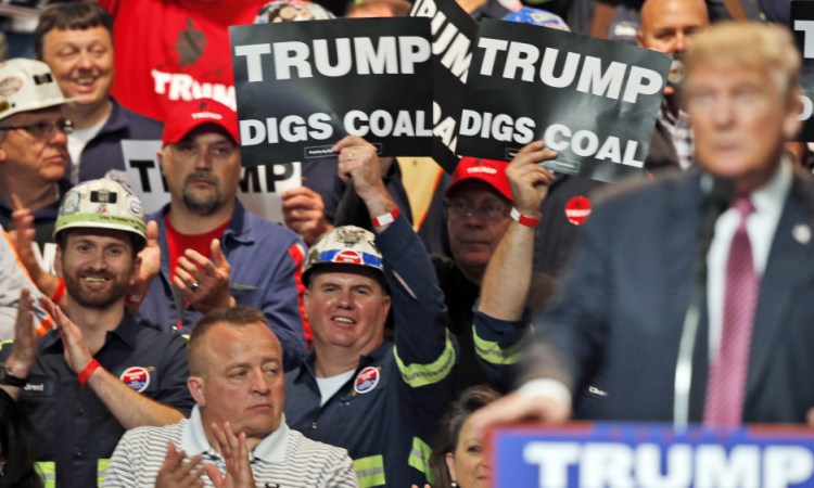 Coal miners wave signs as Republican presidential candidate Donald Trump speaks during a May rally in Charleston, W.Va. Trump's election could signal the end of many of President Obama's signature environmental initiatives.
