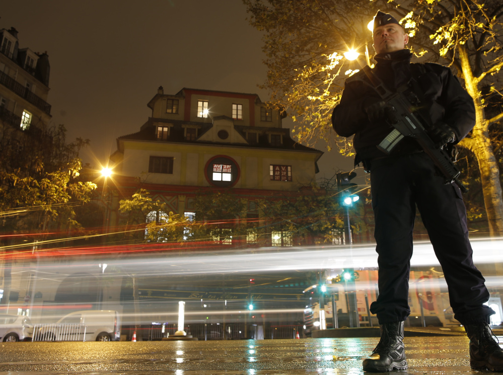 A policeman stands guard at the Bataclan concert hall in Paris on Saturday, where rock star Sting gave a special reopening concert and vowed, "We will not forget them."