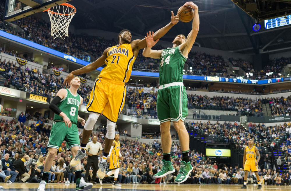 Tyler Zeller, right, of the Celtics attempts to keep a rebound away from Thaddeus Young of the Indiana Pacers during the first half of the Celtics' 105-99 victory Saturday night in Indianapolis.