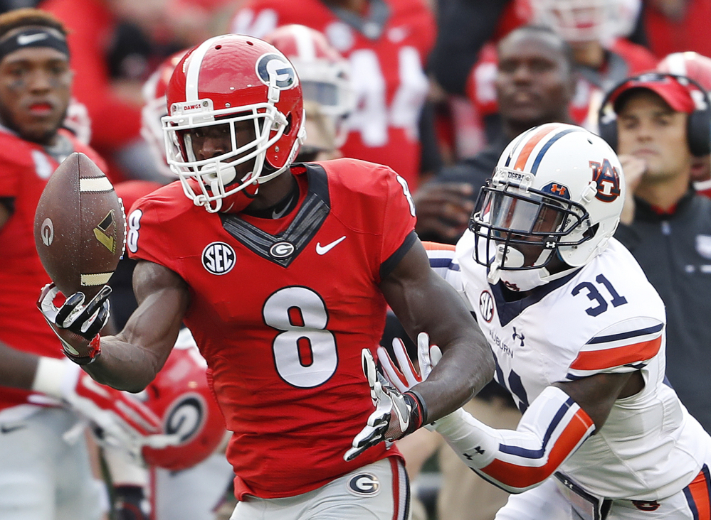 Georgia wide receiver Riley Ridley, left, makes a catch as Auburn defensive back Javaris Davis defends in the first half Saturday in Athens, Georgia. The Bulldogs upset No. 8 Auburn, 13-7.