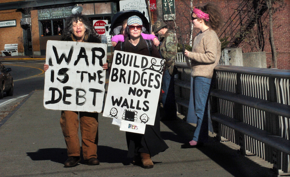 War protesters, from left, Abby Shahn, Lisa Savage and Selene Spivak and others hold signs Sunday on the Margaret Chase Smith bridge in Skowhegan. David Leaming/Morning Sentinel