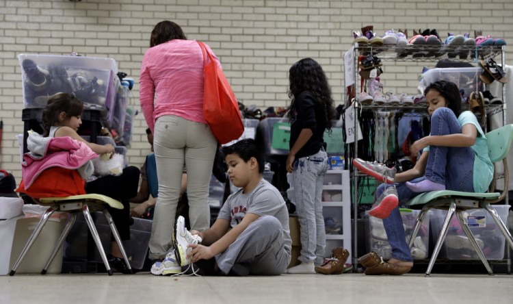 Central American migrants newly released after processing by the U.S. Customs and Border Patrol are fitted for shoes at the Sacred Heart Community Center in the Rio Grande Valley border city of McAllen, Texas, on Sunday.