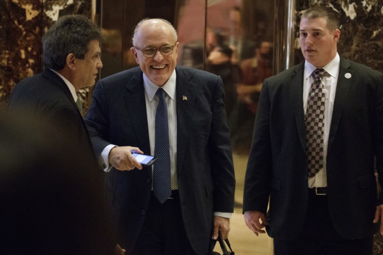 Former New York Mayor Rudy Giuliani, center, leaves Trump Tower on Friday in New York. He is said to be favored for the job of secretary of state.