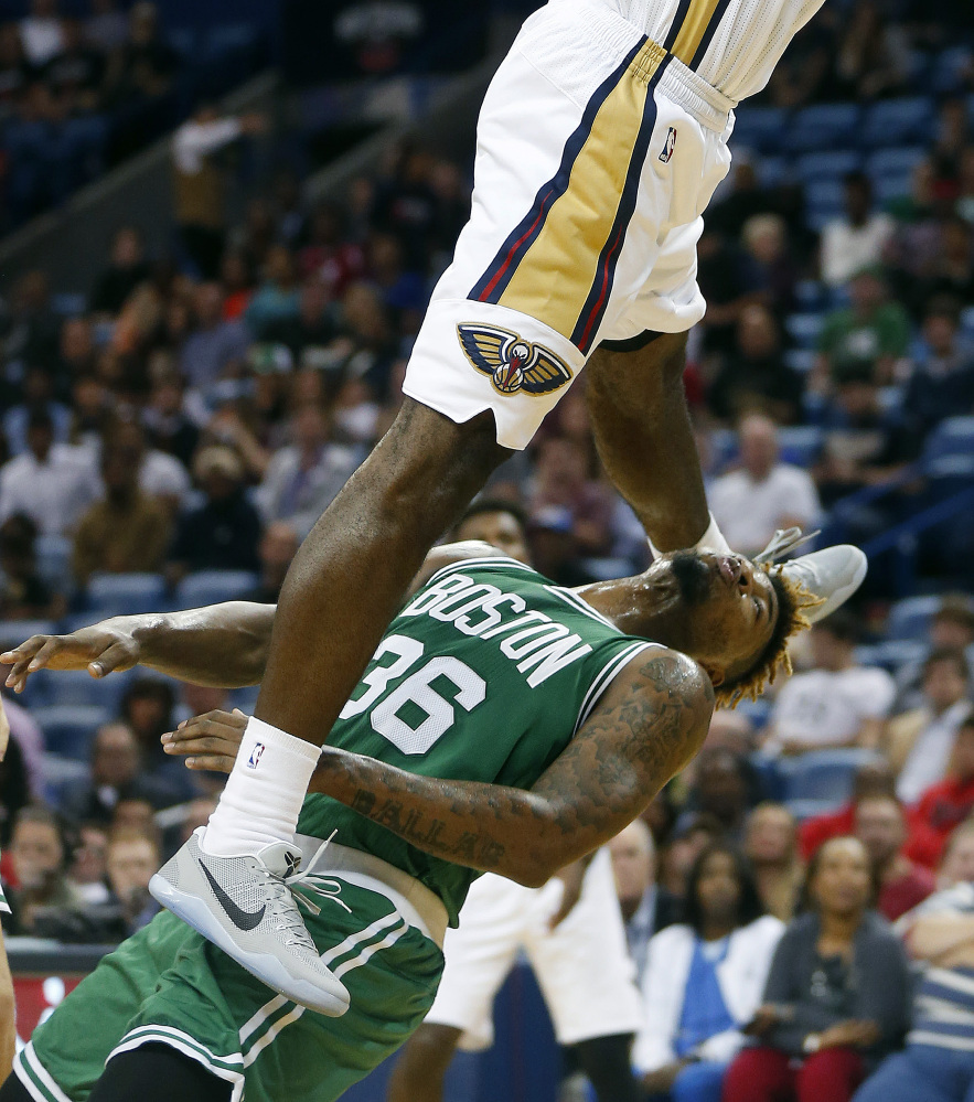 Pelicans forward Solomon Hill slam dunks over Celtics guard Marcus Smart in the first half Monday night. Hill was called for an offensive foul on the play.
