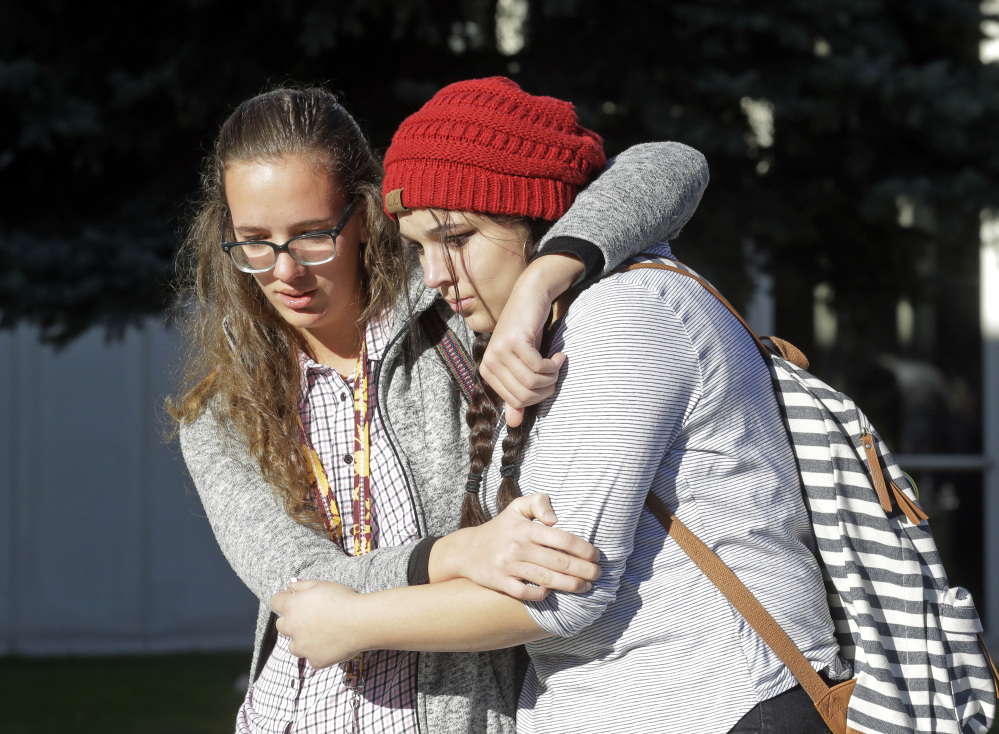 Students Albany Cox, right, and Holly Hilton leave Mountain View High School where several students were stabbed Tuesday in Orem, Utah. Police say a 16-year-old boy was taken into custody after the stabbings.