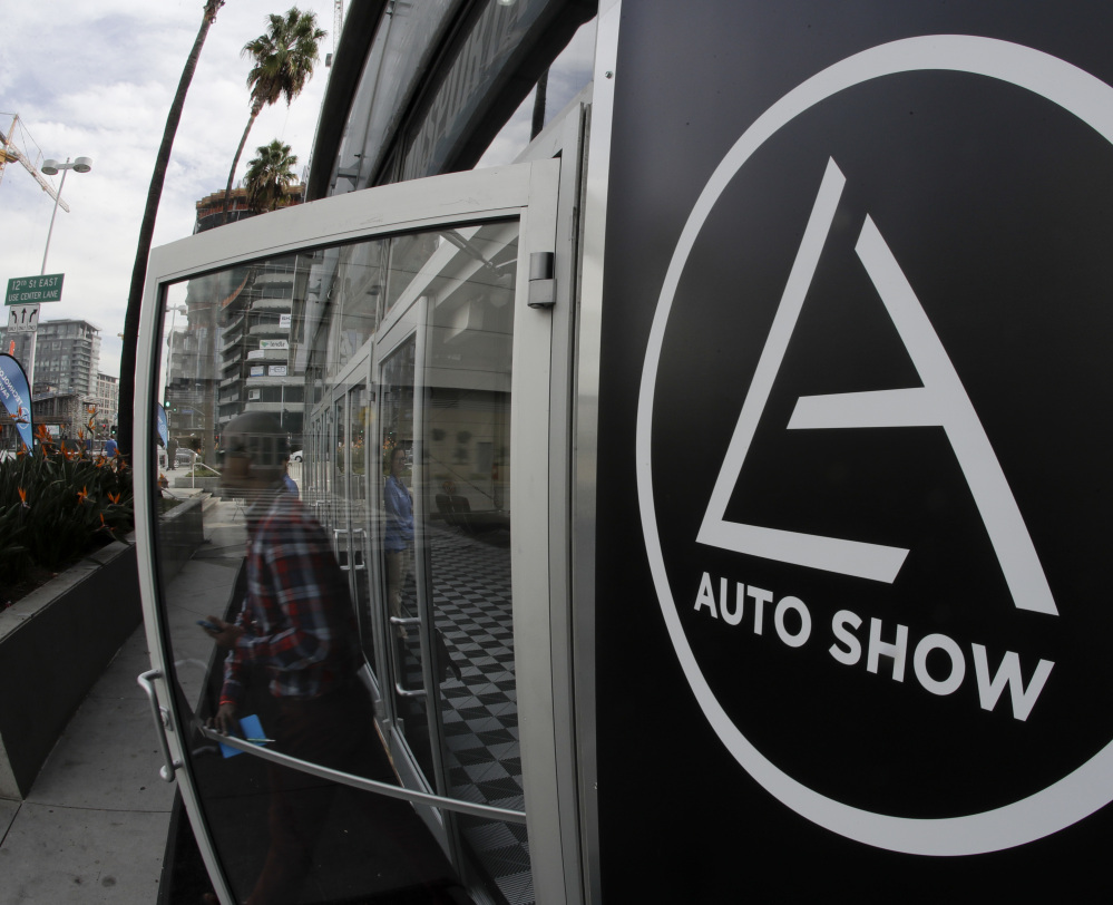 A visitor leaves a display at the Los Angeles Auto Show, where automakers are offering even fewer models with a manual transmission. The full show begins Friday.