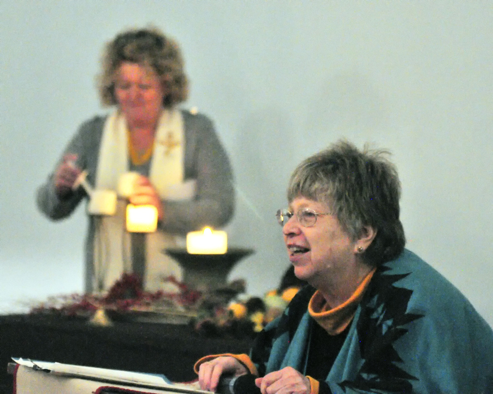 The Rev. Carie Johnsen, of the Unitarian Universalist Community Church, lights candles Tuesday as Claire Cline, of the Spiritual Assembly of Baha'is, does a reading to open the multifaith service of healing, hope and unity sponsored by Capital Area Multi-faith Association at Johnsen's church in Augusta. Representatives from several area faith communities took part in the event.