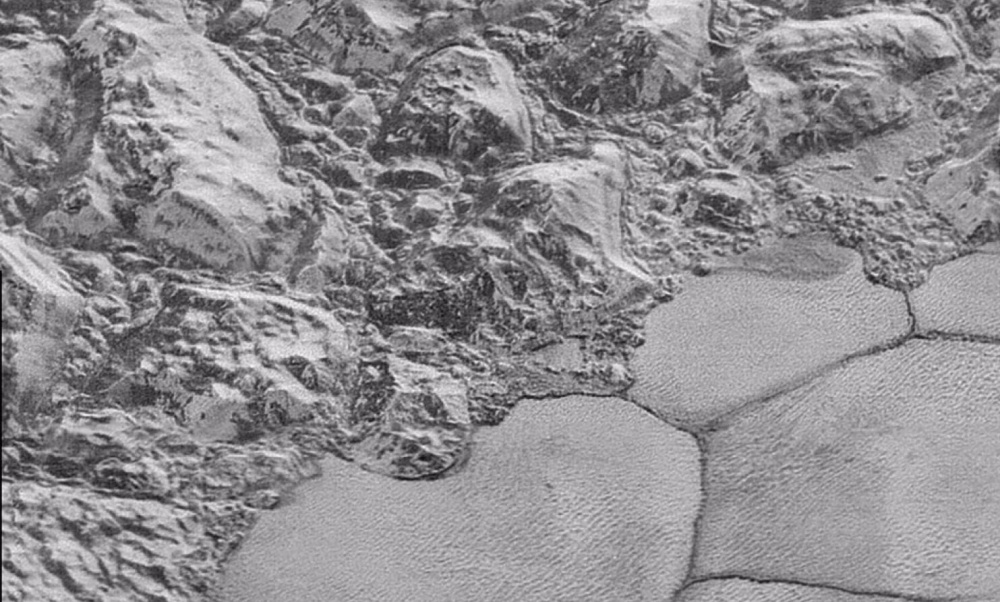 Mountains of water ice cluster on the frozen nitrogen shoreline of Pluto's Sputnik Planitia.