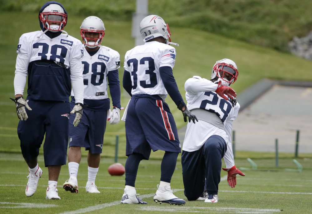 Patriots running backs, from the left, Brandon Bolden, James White, Dion Lewis and LeGarrette Blount, warm up during  Wednesday's practice in Foxborough, Mass.