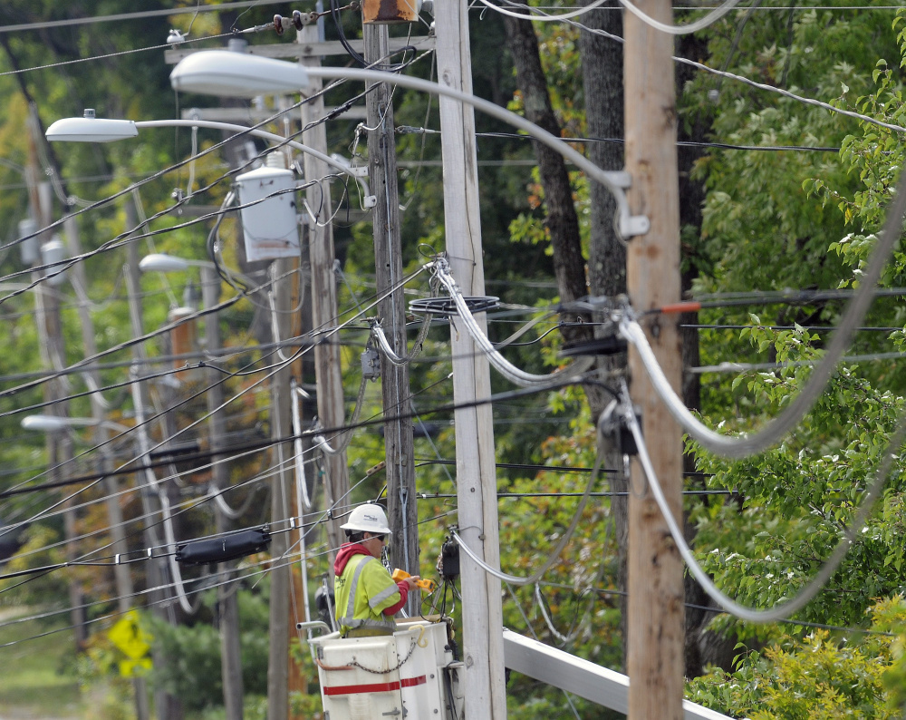 FairPoint lineman Scott Michaud works on a telephone line last year. FairPoint workers were notified Friday that more layoffs are coming. The telecommunications company endured a bitter four-month strike that ended in February 2015. Months later, the company laid off about 80 people in Maine and now another 35-49 are expected to be let go. The Charlotte-based company has had enduring troubles since purchasing Verizon's landline network in Maine, New Hampshire and Vermont  for $2.3 billion in 2007. (Andy Molloy/Kennebec Journal)