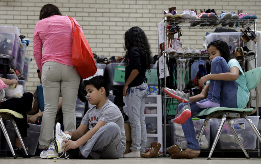 Central American migrants are fitted for shoes in the Rio Grande Valley border city of McAllen, Texas, Sunday. President-elect Donald Trump's plan to deport immigrants with criminal records sounds a lot like what the government has been doing since President Obama took office.