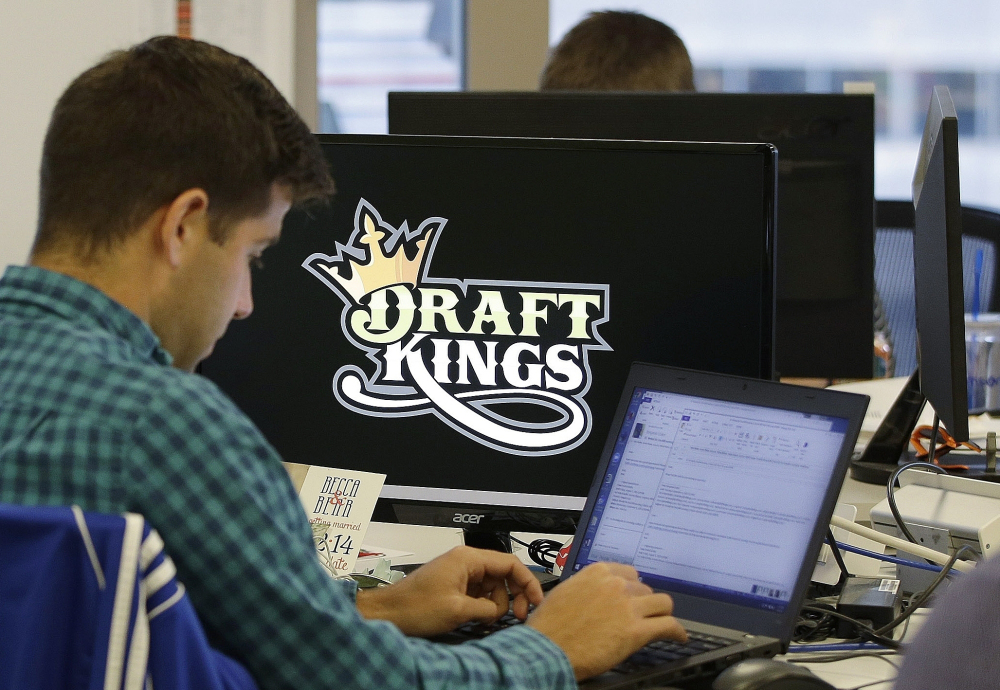 Bear Duker, a marketing manager for strategic partnerships at DraftKings, works at his computer last fall at the company headquarters in Boston. Daily fantasy sports rivals DraftKings and FanDuel have agreed to merge.