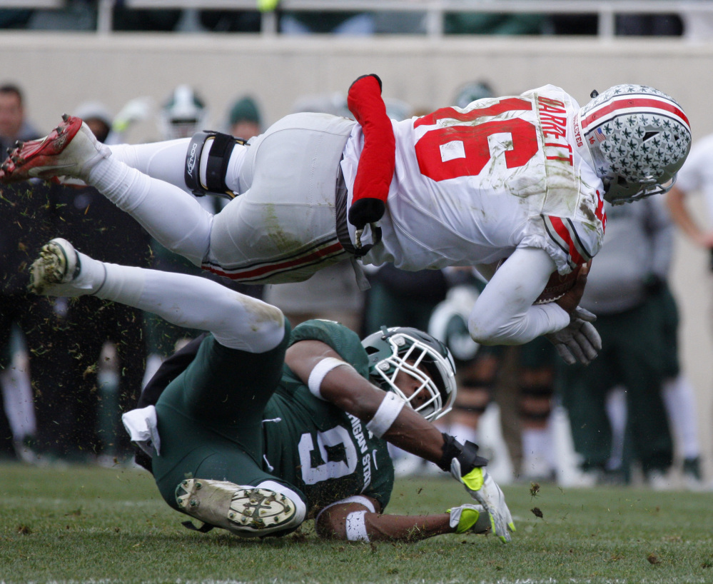Quarterback J.T. Barrett is upended by Montae Nicholson of Michigan State during the second quarter of second-ranked Ohio State's 17-16 victory Saturday. The Buckeyes meet Michigan in a showdown next Saturday.
