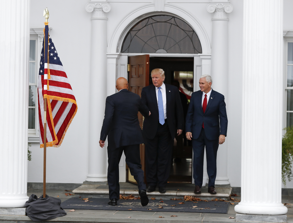 President-elect Donald Trump, center, and Vice President-elect Mike Pence greet Peter N. Kirsanow, a member of the U.S. Commission on Civil Rights, at the Trump National Golf Club Bedminster in Bedminster, N.J., Saturday.