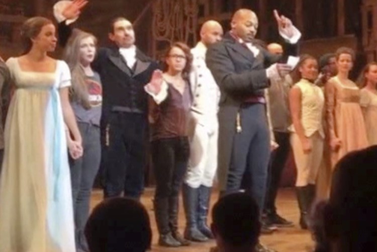 In this image made from a video provided by Hamilton LLC, "Hamilton" actor Brandon Victor Dixon makes a statement from the stage to Vice President-elect Mike Pence on Friday.
