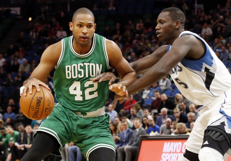 The Timberwolves' Gorgui Dieng reaches for the ball as Al Horford of the Celtics drives in the first quarter. Horford scored 20 points in the win.