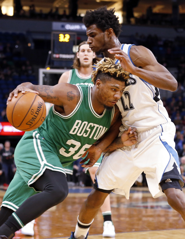 The Celtics' Marcus Smart drives into Minnesota's Andrew Wiggins in the first quarter of an Monday night's game in Minneapolis.