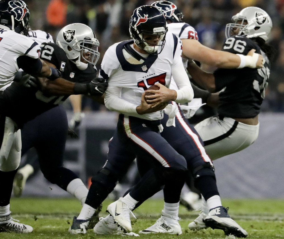 Raiders defensive end Khalil Mack, left, gets a hand on Texans quarterback Brock Osweiler during the first half Monday in Mexico City. Oakland won 27-20.