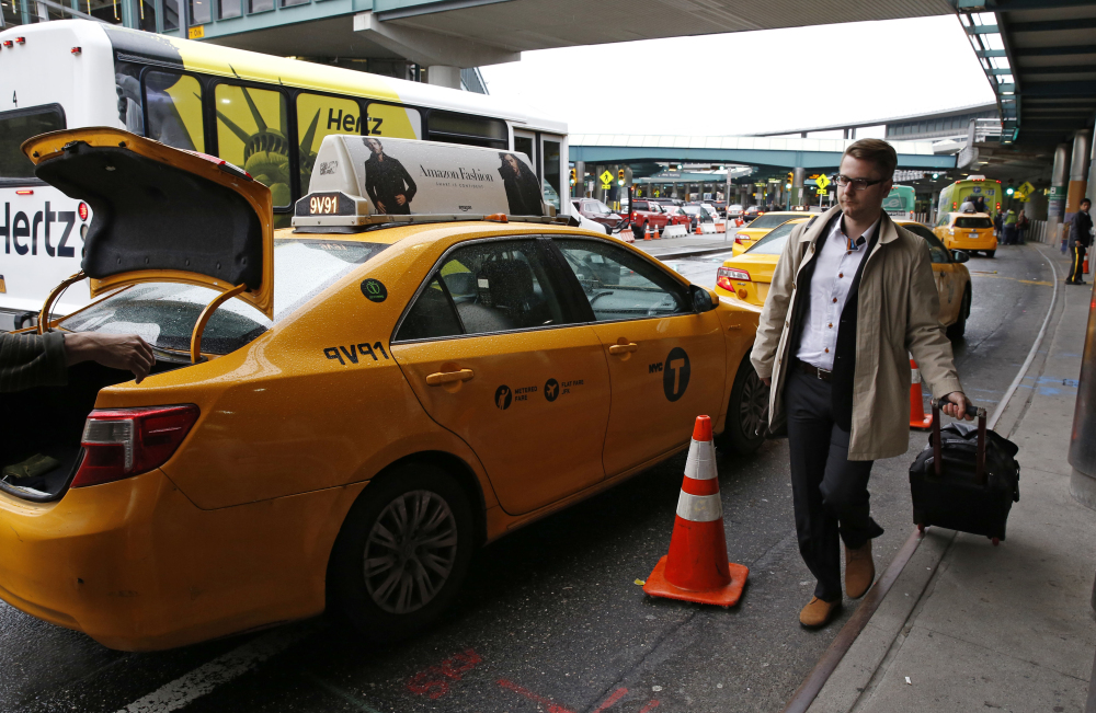 Many big airports are charging a fee of up to $5 – typically passed directly on to travelers – for curb pickups like this one. Some of their reasons for the surcharge: to pay for airport road maintenance or to hire staff to direct traffic and dispatch taxis.