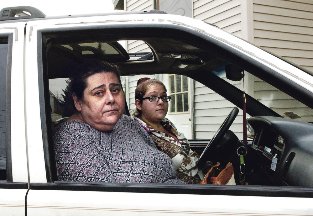 Apartment tenant Cheryl Jack, left, sits in a car on Monday outside the Waterville apartment from which she and her cat were rescued Saturday. Beside her is Crystal Hillman, a support staff employee with Assistance Plus.