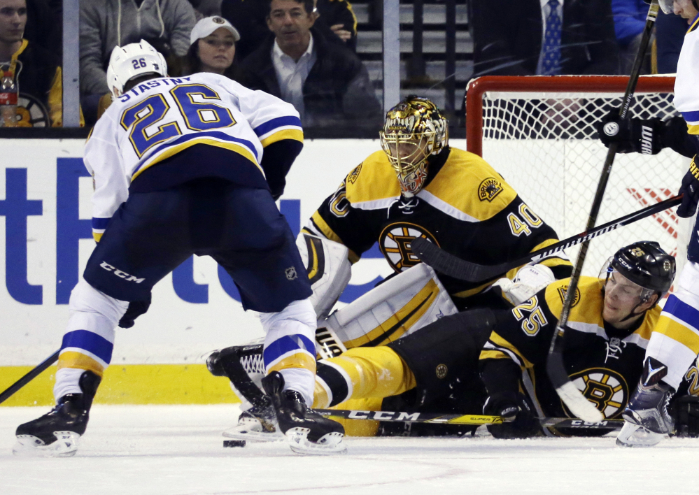 Bruins defenseman Brandon Carlo drops down in front of goalie Tuukka Rask as they defend against Blues center Paul Stastny in the second period.