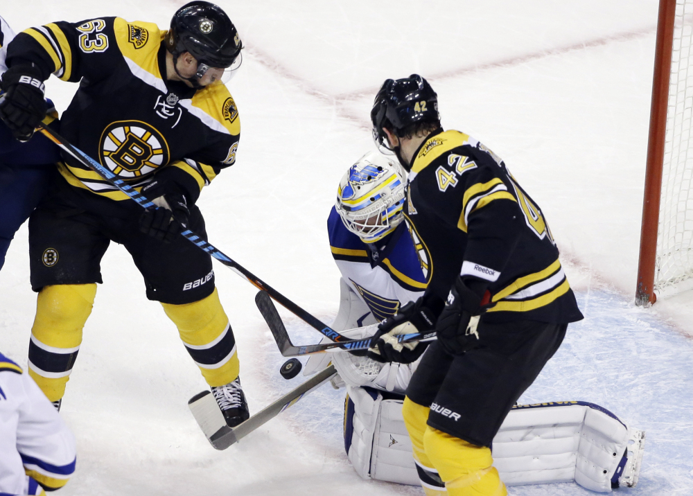 Blues goalie Jake Allen keeps the puck in front as Bruins left wing Brad Marchand (63) and right wing David Backes (42) try to score in the third period Tuesday night in Boston. St. Louis won 4-2.