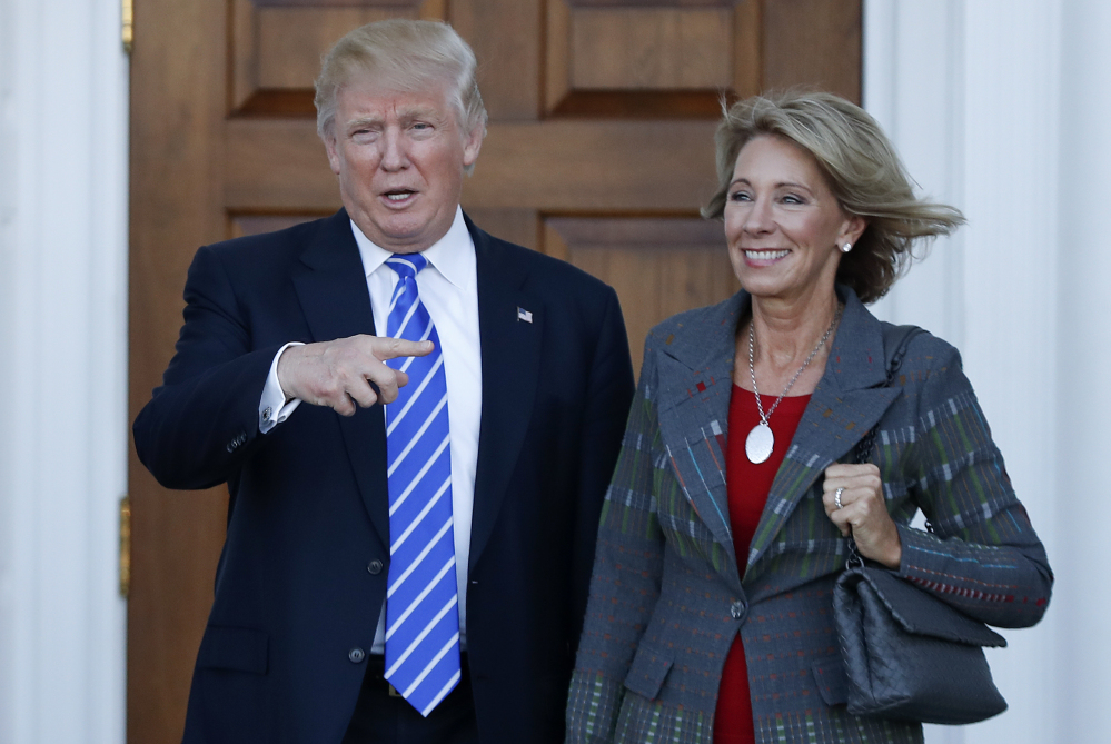 President-elect Donald Trump and Betsy DeVos pose for photographs Saturday at the Trump National Golf Club Bedminster clubhouse in Bedminster, N.J. Trump has chosen DeVos, a charter school advocate, to be education secretary in his administration.