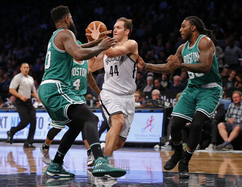 Bojan Bogdanovic of the Nets looks to pass the ball as Boston's Amir Johnson, left, and Jae Crowder defend in the first half Wednesday night in Brooklyn, N.Y.