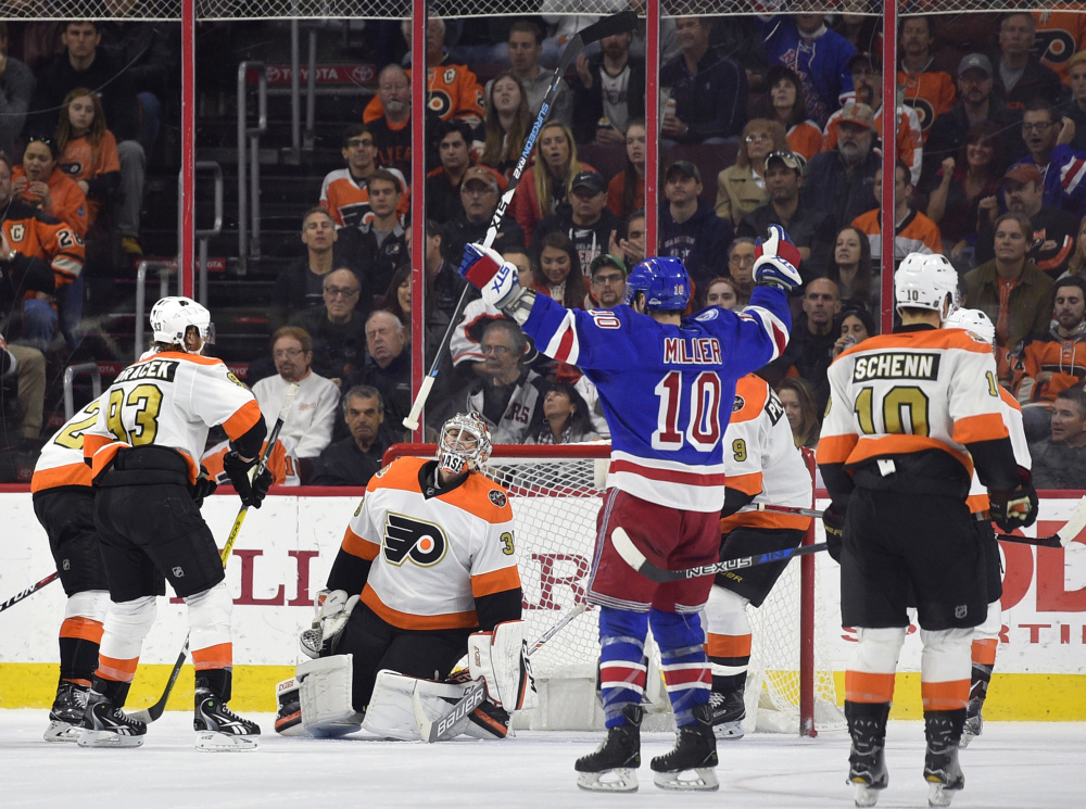 New York's J.T. Miller celebrates after Flyers' goalie Steve Mason, center, allowed a goal during the second period of the Rangers' 3-2 victory Friday in Philadelphia.