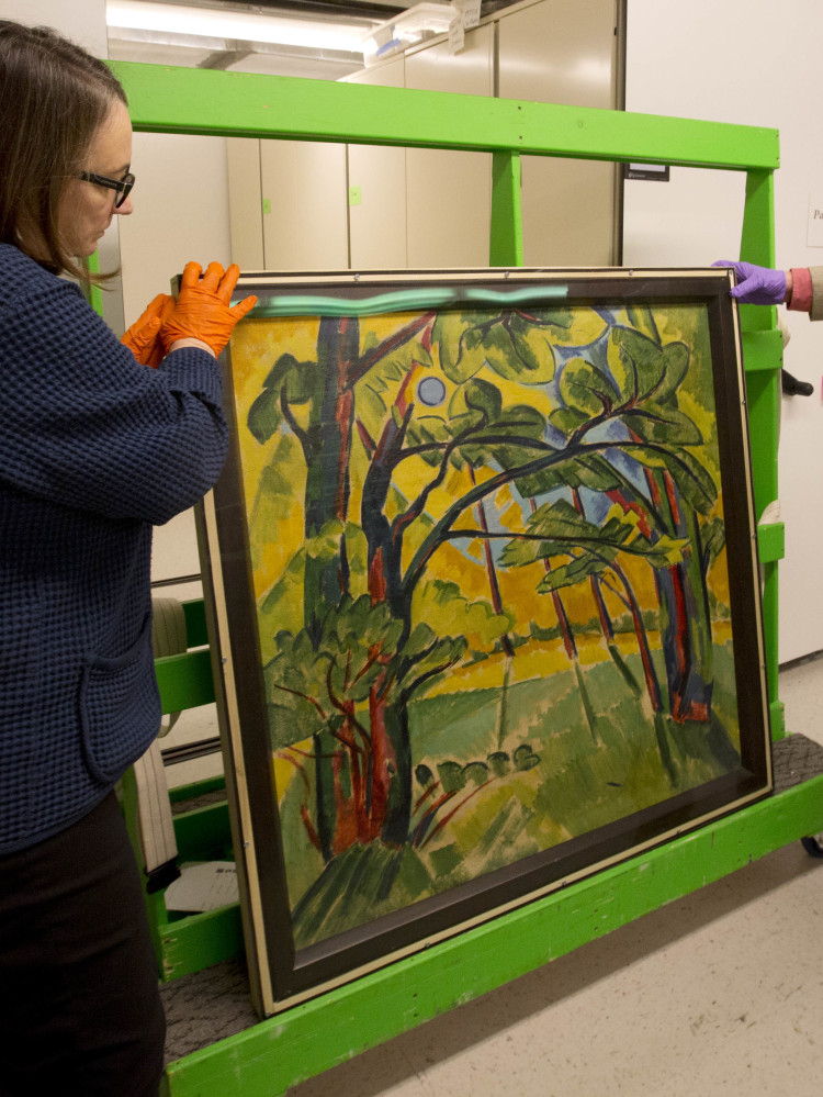 In this Friday Nov. 18, 2016, photo, Karen Papineau, left, and Kurt Sundstrom look at the other side of a painting by German artist Max Pechstein, in Manchester, N.H. The rare double-sided painting is part of a new exhibit at the Currier Museum of Art. (AP Photo/Jim Cole)