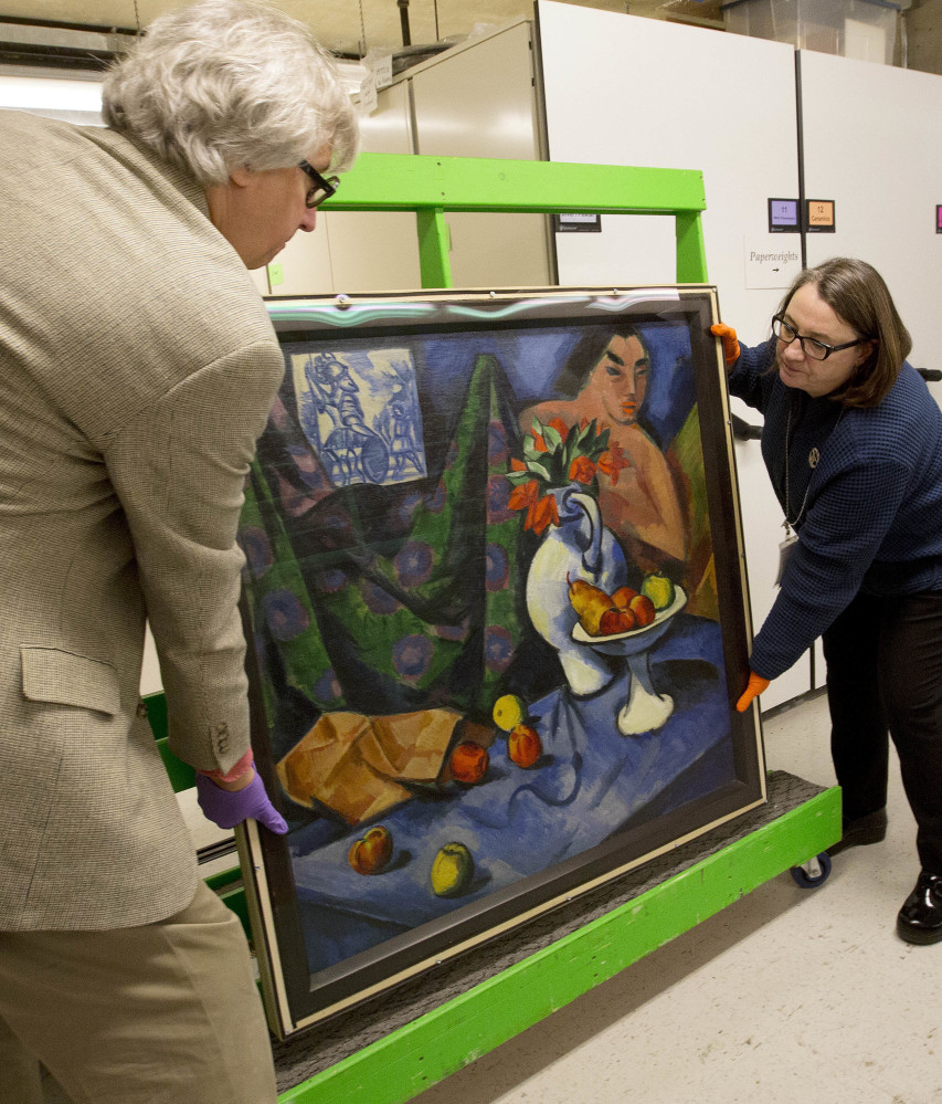 Kurt Sundstrom, curator of the Currier Museum of Art in Manchester, N.H., and Karen Papineau prepare a two-sided painting by German artist Max Pechstein for display. Previous owners had exhibited only the still life, at left, but not the landscape.