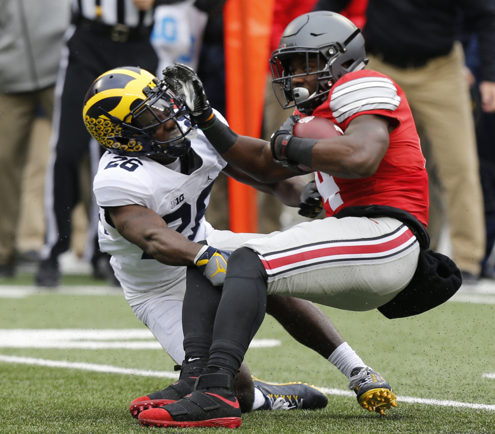 Ohio State running back Curtis Samuel, right, is tackled by Michigan cornerback Jourdan Lewis during the first half of the Buckeyes' 30-27 win Saturday in Columbus, Ohio.