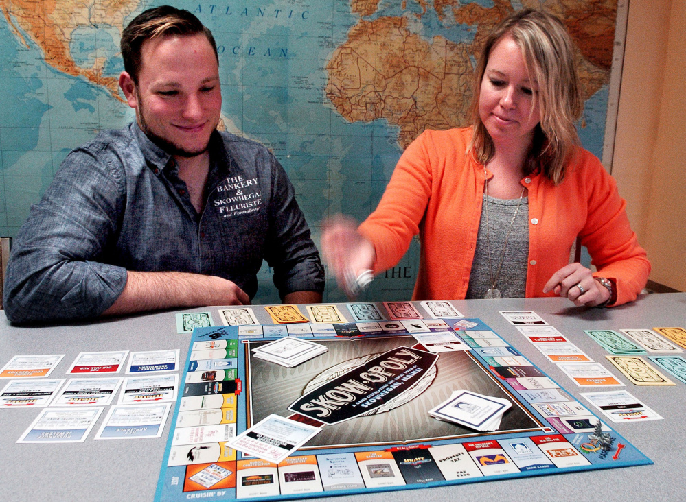 Matt DuBois, co-owner of The Bankery and president of the Main Street Skowhegan board, and Executive Director Kristina Cannon begin a round of the Skowopoly board game at the Skowhegan office on Wednesday. 
David Leaming/ Morning Sentinel

